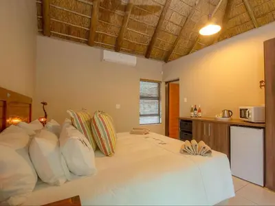 a bedroom with a large white bed with pillows at The Den at Kruger 3479 in Marloth Park