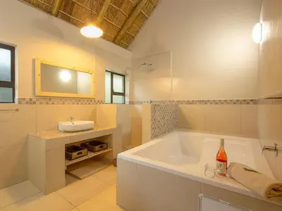 a large bathroom with a tub and a sink at The Den at Kruger 3479 in Marloth Park