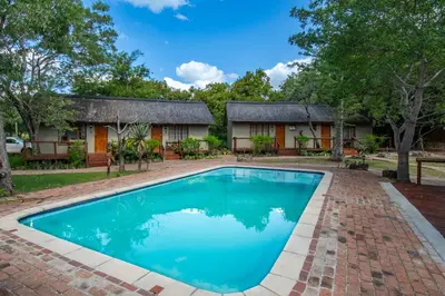 a house with a swimming pool in front of it at Thornhill Safari Lodge in Hoedspruit