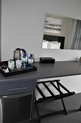 a desk with a tray with water bottles on it at Mahem Manor Guesthouse in Brits