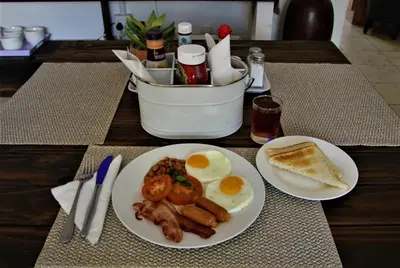 a table with two plates of breakfast food on it at Mahem Manor Guesthouse in Brits