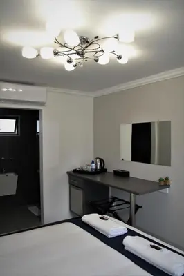 a bedroom with a desk and a bed at Mahem Manor Guesthouse in Brits