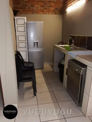 a kitchen with a chair and a refrigerator at VuguVugu - At home in Africa in Marloth Park