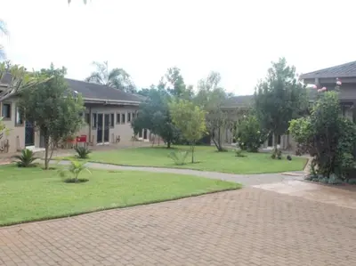 a house with a brick driveway in front of a yard at PW Heights Private Guest House in Thohoyandou