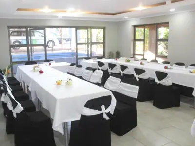 a row of tables and chairs in a room at PW Heights Private Guest House in Thohoyandou