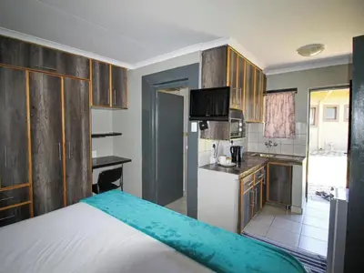 a small kitchen with a bed in a room at PW Heights Private Guest House in Thohoyandou