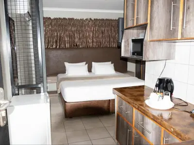 a hotel room with a bed and a kitchen at PW Heights Private Guest House in Thohoyandou