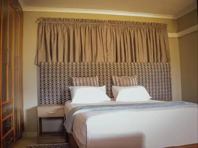 a bedroom with a bed with two pillows and a window at PW Heights Private Guest House in Thohoyandou