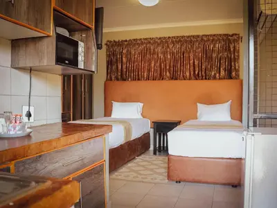a hotel room with two beds and a kitchen at PW Heights Private Guest House in Thohoyandou
