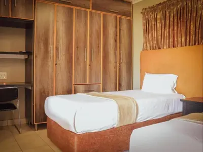 a hotel room with two beds and a kitchen at PW Heights Private Guest House in Thohoyandou