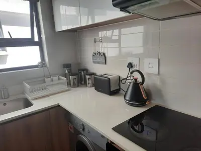 a kitchen with a sink and a washing machine on a counter at 396 The Blyde Crystal Clear Lagoon 2 Bedroom Penthouse Apartment in Pretoria