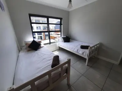 a bedroom with two beds and a window at 396 The Blyde Crystal Clear Lagoon 2 Bedroom Penthouse Apartment in Pretoria
