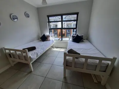 two beds in a room with a window at 396 The Blyde Crystal Clear Lagoon 2 Bedroom Penthouse Apartment in Pretoria