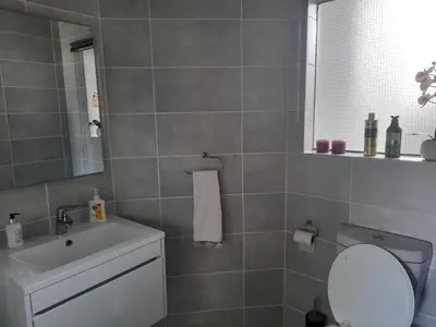 a bathroom with a sink and a toilet and a mirror at 396 The Blyde Crystal Clear Lagoon 2 Bedroom Penthouse Apartment in Pretoria