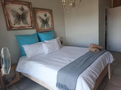 a bed in a bedroom with two pictures of butterflies at 396 The Blyde Crystal Clear Lagoon 2 Bedroom Penthouse Apartment in Pretoria