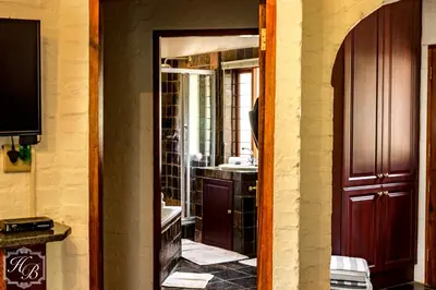 a doorway to a bathroom with a sink and a mirror at Heysbrook Estate - Luxurious lodges in a private valley in Waterval-Onder