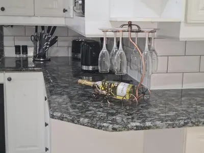 a bunch of wine bottles on a counter in a kitchen at Cozy Cabin in Midrand