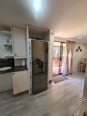 a kitchen with a refrigerator in the middle of a room at Cozy Cabin in Midrand