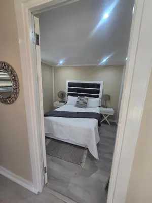 a bedroom with a bed with a white bedspread at Cozy Cabin in Midrand