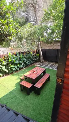 a picnic table sitting on a patch of green grass at Cozy Cabin in Midrand