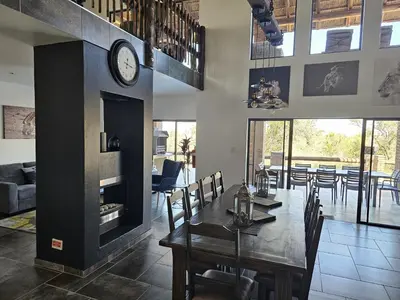 a dining room with a table and a clock on the wall at 636 Itaga Safari Lodge, Mabalingwe Nature Reserve in Mabula