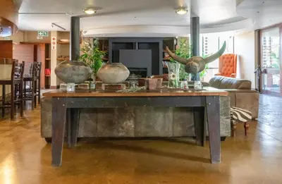 a table in a living room with vases on it at Zebula Boutique Hotel in Mabula