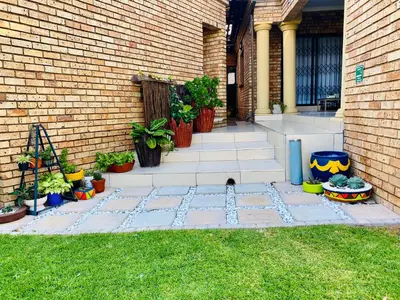 a patio with potted plants next to a brick building at Mrhali Boutique Guest House in Kwamhlanga