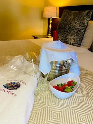 a bowl of strawberries on top of a bed at Mrhali Boutique Guest House in Kwamhlanga