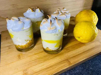 three desserts in glasses on a wooden tray with a lemon at Mrhali Boutique Guest House in Kwamhlanga