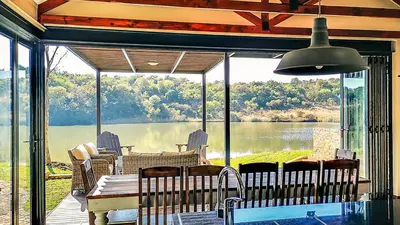 a screened in porch with a view of a lake at Lodge @ Bankenkloof Private Game Reserve in Tierpoort