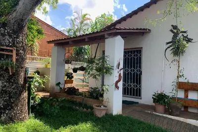 a white house with a gate and some plants at Plum Cottage in Nelspruit