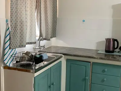 a kitchen with green cabinets and a sink at Plum Cottage in Nelspruit