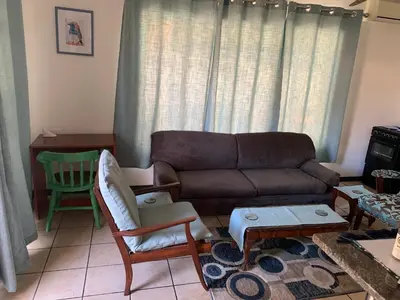 a living room with a couch and a table at Plum Cottage in Nelspruit