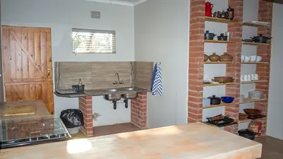 a kitchen with a sink and a brick wall at Buffalo House @Bankenkloof Private Game Reserve in Tierpoort