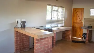 a kitchen with a brick counter top and a stove at Buffalo House @Bankenkloof Private Game Reserve in Tierpoort
