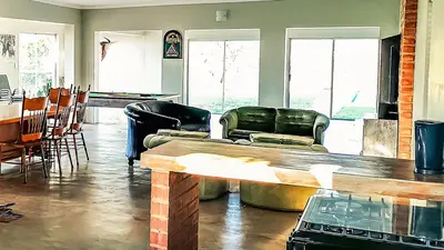 a living room with leather chairs and a table at Buffalo House @Bankenkloof Private Game Reserve in Tierpoort