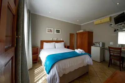 a bedroom with a bed and a table and chair at @ Marula in Mokopane