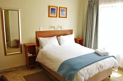 a bedroom with a bed and a large window at @ Marula in Mokopane