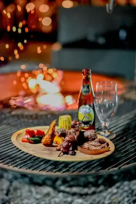 a plate of food on a table with a wine glass at Moditlo River Lodge in Hoedspruit