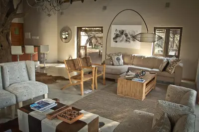 a living room with a couch and a table at Moditlo River Lodge in Hoedspruit