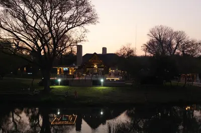 a lit up house with a pond in front of it at Mologa River Lodge in Rust de Winter