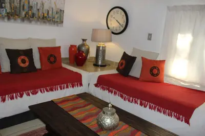 two beds in a room with a clock on the wall at The Sabie Town House Guest Lodge in Sabie