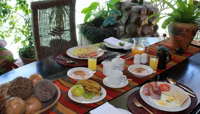 a breakfast table with breakfast foods and orange juice at The Sabie Town House Guest Lodge in Sabie