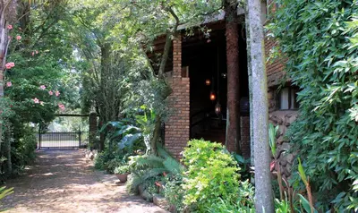 a brick building with a pathway leading to a garden at The Sabie Town House Guest Lodge in Sabie