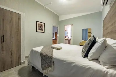 a bedroom with a large bed with white sheets and pillows at Tranquil Nest in Hazyview