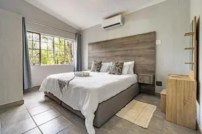 a bedroom with a large bed and a window at Tranquil Nest in Hazyview