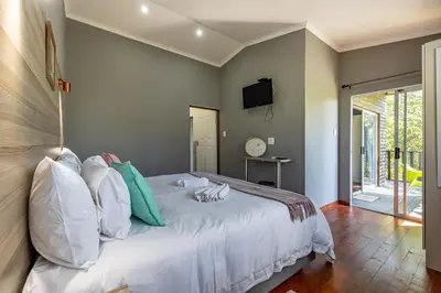 a bedroom with a large bed with white pillows at Tranquil Nest in Hazyview