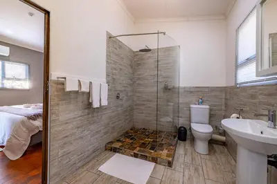 a bathroom with a shower and a toilet and a sink at Tranquil Nest in Hazyview