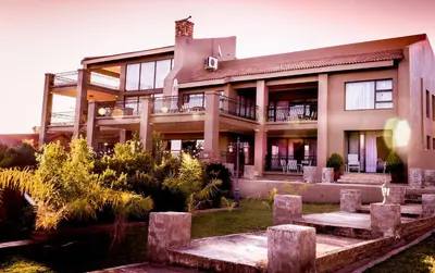 a house with a garden in front of it at Château La Mer Exclusive Guesthouse & Spa in Hartbeespoort