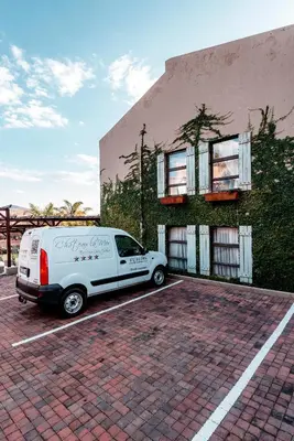 a white van parked in a parking lot in front of a building at Château La Mer Exclusive Guesthouse & Spa in Hartbeespoort